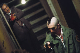Robert De Niro as Travis Bickle with Murray Moston behind him during the killing spree in Taxi Driver (1976)